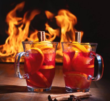 Bir bardak yılbaşı şarabı ateşe karşı sıcak tutar. Gluhwein veya sıcak şarap. Geleneksel kış içeceği 