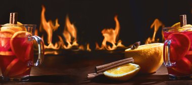 Bir bardak yılbaşı şarabı ateşe karşı sıcak tutar. Gluhwein veya sıcak şarap. Geleneksel kış içeceği. 