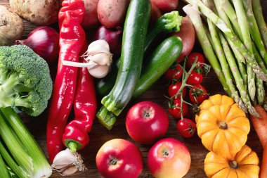 Tahta bir masanın üstünde çeşitli çiğ sebzeler.. 