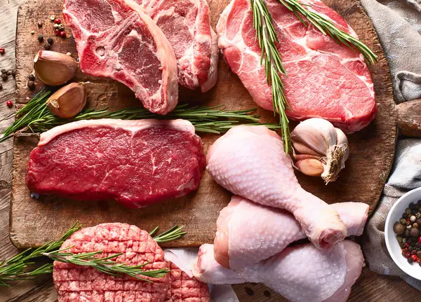 Farklı türde çiğ et, sığır eti, kuzu eti, ahşap bir tahtanın üzerinde tavuk. Üst görünüm.