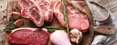 Farklı türde çiğ et, sığır eti, kuzu eti, ahşap bir tahtanın üzerinde tavuk. Üst görünüm.