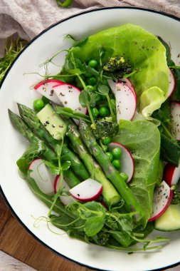 Bezelyeli taze kuşkonmaz salatası, turşu, salatalık ve salatalık. Üst görünüm.