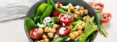 Domates, salatalık, salata, nohut ve peynirli vejetaryen nohut salatası hafif bir arka planda. Sağlıklı bir yaşam tarzı. Üst manzara, panorama