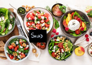 Çilekli çeşitli yaz salataları, otlar. Hafif arkaplanlı sağlıklı salata, şeftali, burrata, yabanmersini ve ceviz. Sağlıklı yemek için taze yararlı yemek. Üst görünüm.