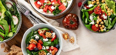 Çilekli çeşitli yaz salataları, otlar. Hafif arkaplanlı sağlıklı salata, şeftali, burrata, yabanmersini ve ceviz. Sağlıklı yemek için taze yararlı yemek. Üst görünüm.