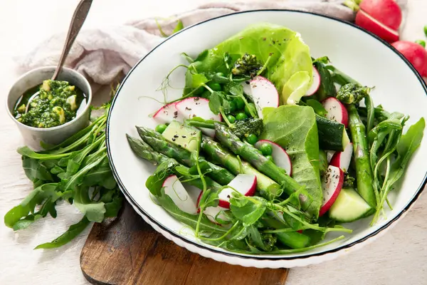Bezelyeli taze kuşkonmaz salatası, turşu, salatalık ve salatalık. Üst görünüm.