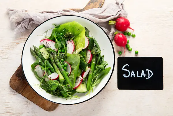 Bezelyeli taze kuşkonmaz salatası, turşu, salatalık ve salatalık. Üst görünüm.