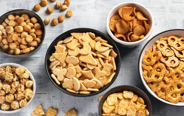 Gri arka planda kraker ve patlamış mısır karışımı. Üst görünüm. 