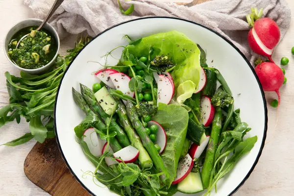 Bezelyeli taze kuşkonmaz salatası, turşu, salatalık ve salatalık. Üst görünüm.