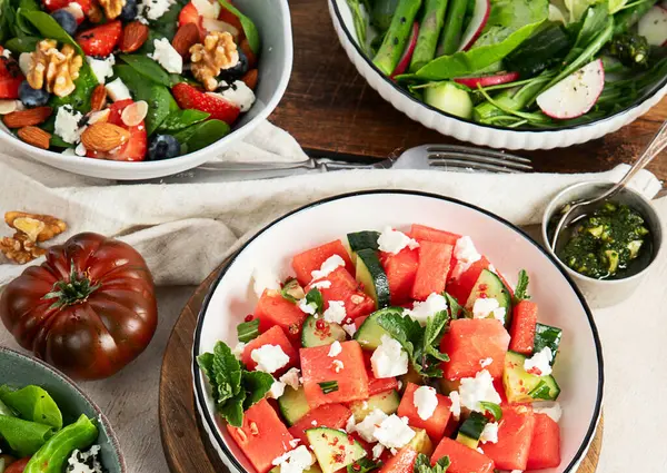 Çilekli çeşitli yaz salataları, otlar. Hafif arkaplanlı sağlıklı salata, şeftali, burrata, yabanmersini ve ceviz. Sağlıklı yemek için taze yararlı yemek. Üst görünüm.