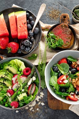 Sebzeli, meyveli ve fındıklı taze vejetaryen yaz salataları. Üst görünüm.