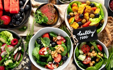 Sebzeli, meyveli ve fındıklı taze vejetaryen yaz salataları. Üst görünüm.