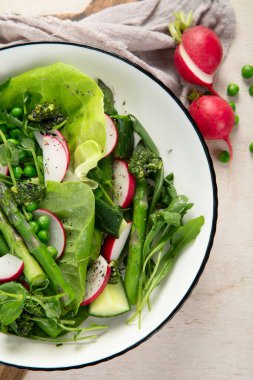 Bezelyeli taze kuşkonmaz salatası, turşu, salatalık ve salatalık. Üst görünüm.