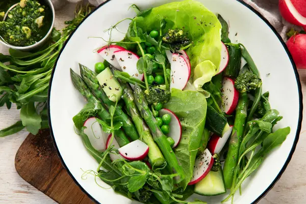 Bezelyeli taze kuşkonmaz salatası, turşu, salatalık ve salatalık. Üst görünüm.