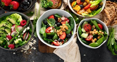 Sebzeli, meyveli ve fındıklı taze vejetaryen yaz salataları. Üst Manzara. Boşluğu kopyala.