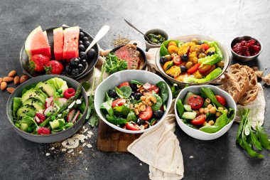 Sebzeli, meyveli ve fındıklı taze vejetaryen yaz salataları. Üst görünüm.