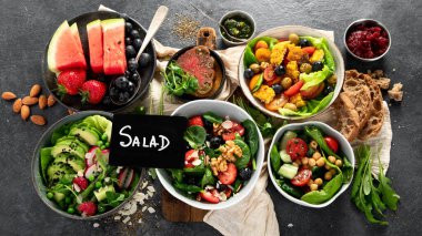 Sebzeli, meyveli ve fındıklı taze vejetaryen yaz salataları. Üst görünüm.