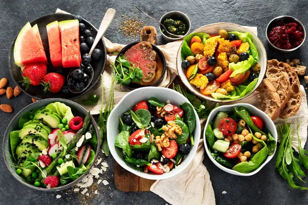 Sebzeli, meyveli ve fındıklı taze vejetaryen yaz salataları. Üst görünüm.