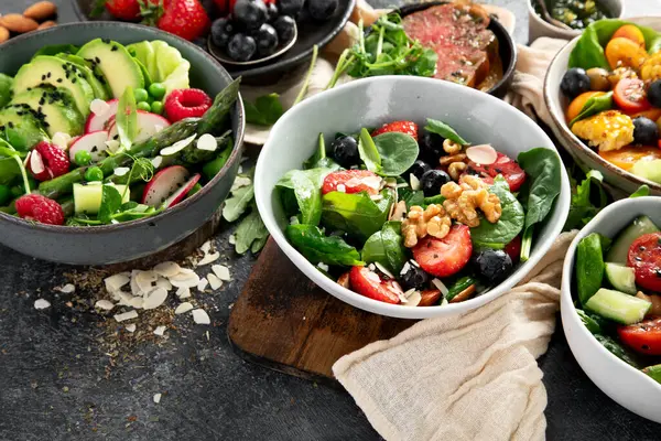 Sebzeli, meyveli ve fındıklı taze vejetaryen yaz salataları. Üst görünüm.