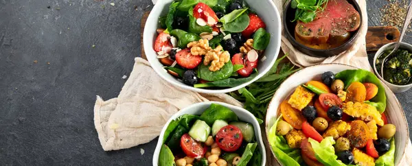 Sebzeli, meyveli ve fındıklı taze vejetaryen yaz salataları. Üst Manzara. Kopyalama alanı olan Panorama.