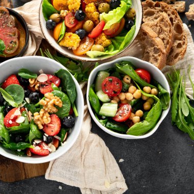 Sebzeli, meyveli ve fındıklı taze vejetaryen yaz salataları. Üst görünüm.