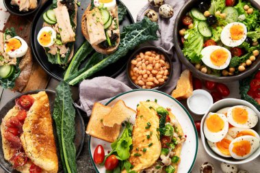 Kızarmış, kaynatılmış ve çırpılmış yumurtalarla birlikte beyaz arka planda. Üst görünüm. 