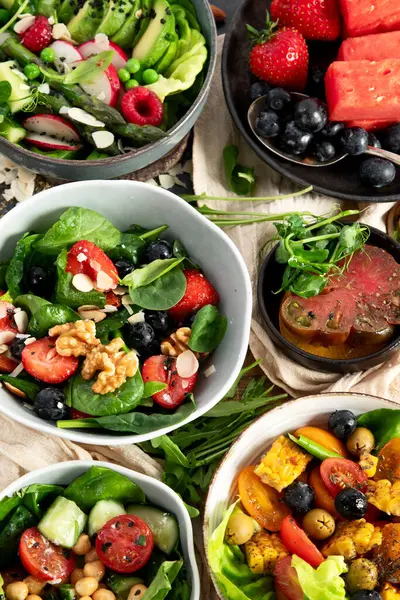 Sebzeli, meyveli ve fındıklı taze vejetaryen yaz salataları. Üst görünüm.