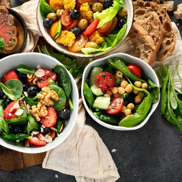 Sebzeli, meyveli ve fındıklı taze vejetaryen yaz salataları. Üst görünüm.