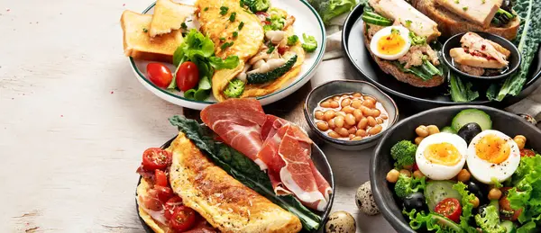 Kızarmış, kaynatılmış ve çırpılmış yumurtalarla birlikte beyaz arka planda. Üst Manzara. Kopyalama alanı olan Panorama.