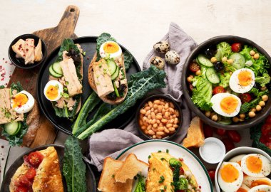 Kızarmış, kaynatılmış ve çırpılmış yumurtalarla birlikte beyaz arka planda. Üst Manzara. Boşluğu kopyala.