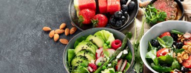 Sebzeli, meyveli ve fındıklı taze vejetaryen yaz salataları. Üst Manzara. Kopyalama alanı olan Panorama.