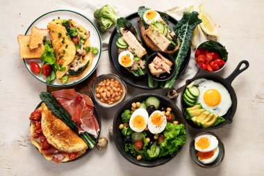 Kızarmış, kaynatılmış ve çırpılmış yumurtalarla birlikte beyaz arka planda. Üst görünüm. 