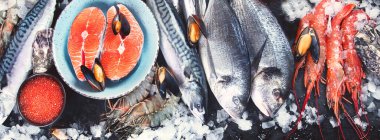 Siyah arka planda taze balık ve deniz ürünleri. Üst manzara, düz yatak, panorama, pankart  