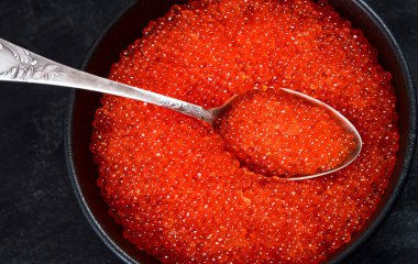 Somon yumurtası. Siyah arka planda kırmızı havyar. Üst görünüm