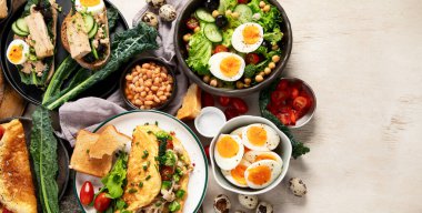 Kızarmış, kaynatılmış ve çırpılmış yumurtalarla birlikte beyaz arka planda. Üst Manzara. Boşluğu kopyala.