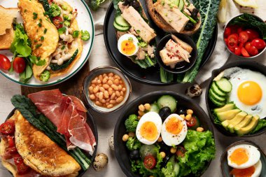 Kızarmış, kaynatılmış ve çırpılmış yumurtalarla birlikte beyaz arka planda. Üst görünüm. 