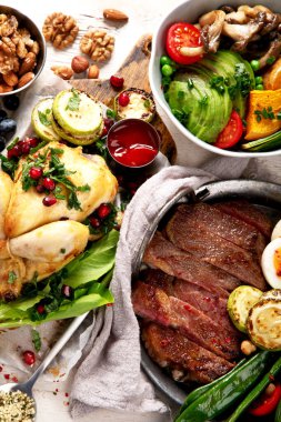 Et ızgara, balık, kızarmış patates, sebze, salata ve soslu yemek masası. Üst görünüm.