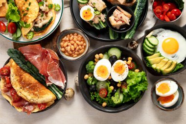 Kızarmış, kaynatılmış ve çırpılmış yumurtalarla birlikte beyaz arka planda. Üst görünüm. 