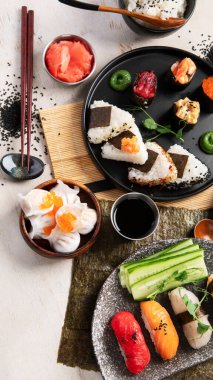 Geleneksel Japon mutfağı. Suşi, somon balığı, ton balığı ve sebzeli, hafif bir arka planda servis ediliyor. Asya yemekleri. Üst görünüm