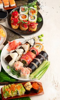 Suşi ve ekmek karışımı. Hafif arka planda Japon geleneksel yemekleri. Üst Manzara. Boşluğu kopyala.