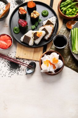 Geleneksel Japon mutfağı. Suşi, somon balığı, ton balığı ve sebzeli, hafif bir arka planda servis ediliyor. Asya yemekleri. Üst Manzara. Boşluğu kopyala.