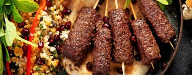 Soslu ızgara Türk kebabı ve koyu arkaplanda pilav. Adana durum. Üst yaşam