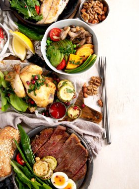 Et ızgara, balık, kızarmış patates, sebze, salata ve soslu yemek masası. Üst Manzara. Boşluğu kopyala.