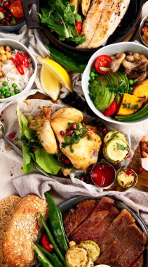 Et ızgara, balık, kızarmış patates, sebze, salata ve soslu yemek masası. Üst görünüm.