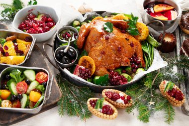 Kızarmış tavuk, pasta, şarap ve hafif arka planda atıştırmalıklarla Noel yemeği. Üst görünüm.