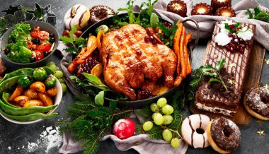 Kızarmış tavuk, patates, kek ve siyah arka planda aperatiflerle Noel yemeği. Üst görünüm