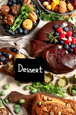 Çeşitli vejetaryen tatlılar, çikolatalı pasta, muzlu pasta, fındık ve tatlı. Üst görünüm. 