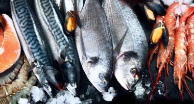 Siyah arka planda balık ve deniz ürünleri. Üst görünüm 