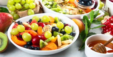 Gri arka planda sağlıklı taze meyve salatası.