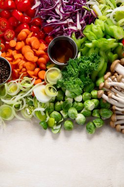 Dilimlenmiş ve rengarenk taze sebzeler hafif bir arka planda yemek hazırlama. Üst Manzara. Boşluğu kopyala.